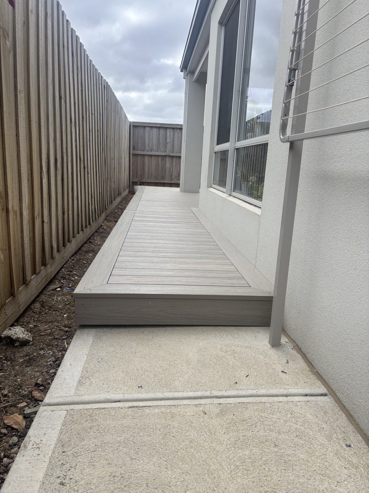 A long composite run down the side of a house, edge held straight over distance